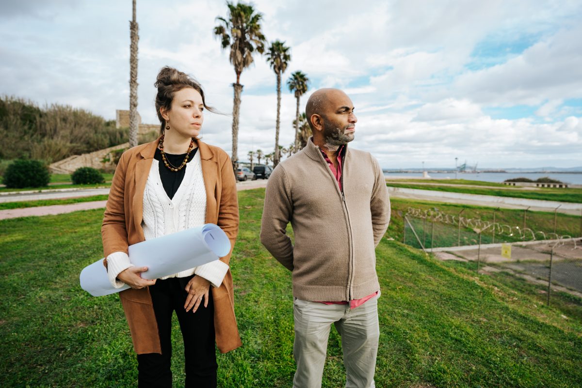 Een vrouw en een man kijken uit over de locatie van een nieuwe waterstoffabriek in Portugal met een kaart in hun handen.
